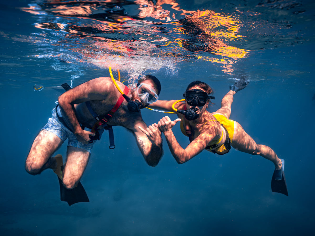 Two SNUBA guests giving a shaka sign underwater in Bonaire